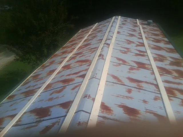 Rusted metal roof panels with new wood purlins before replacement — Storm Damage Roof Repair in Derry by Roofing Brothers