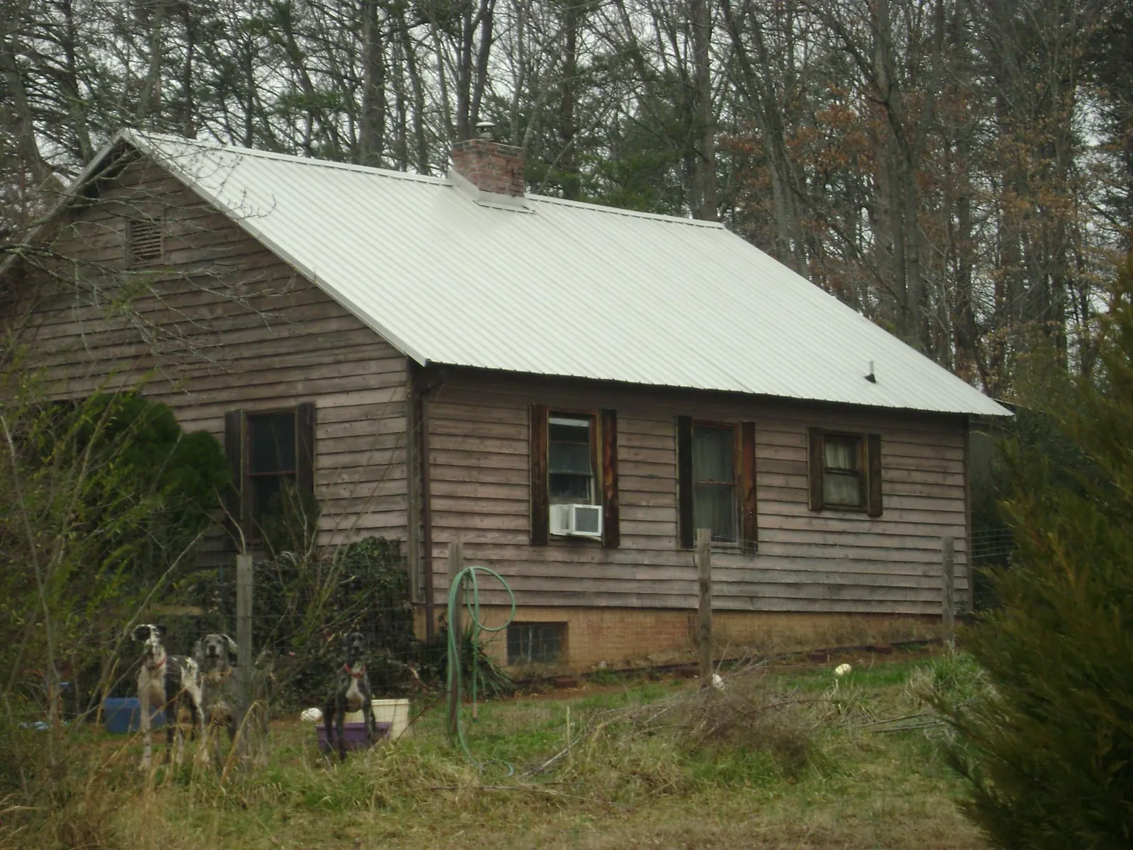 White metal roof on an old wood sided farmhouse, from a Metal Roof Installation job in Derry